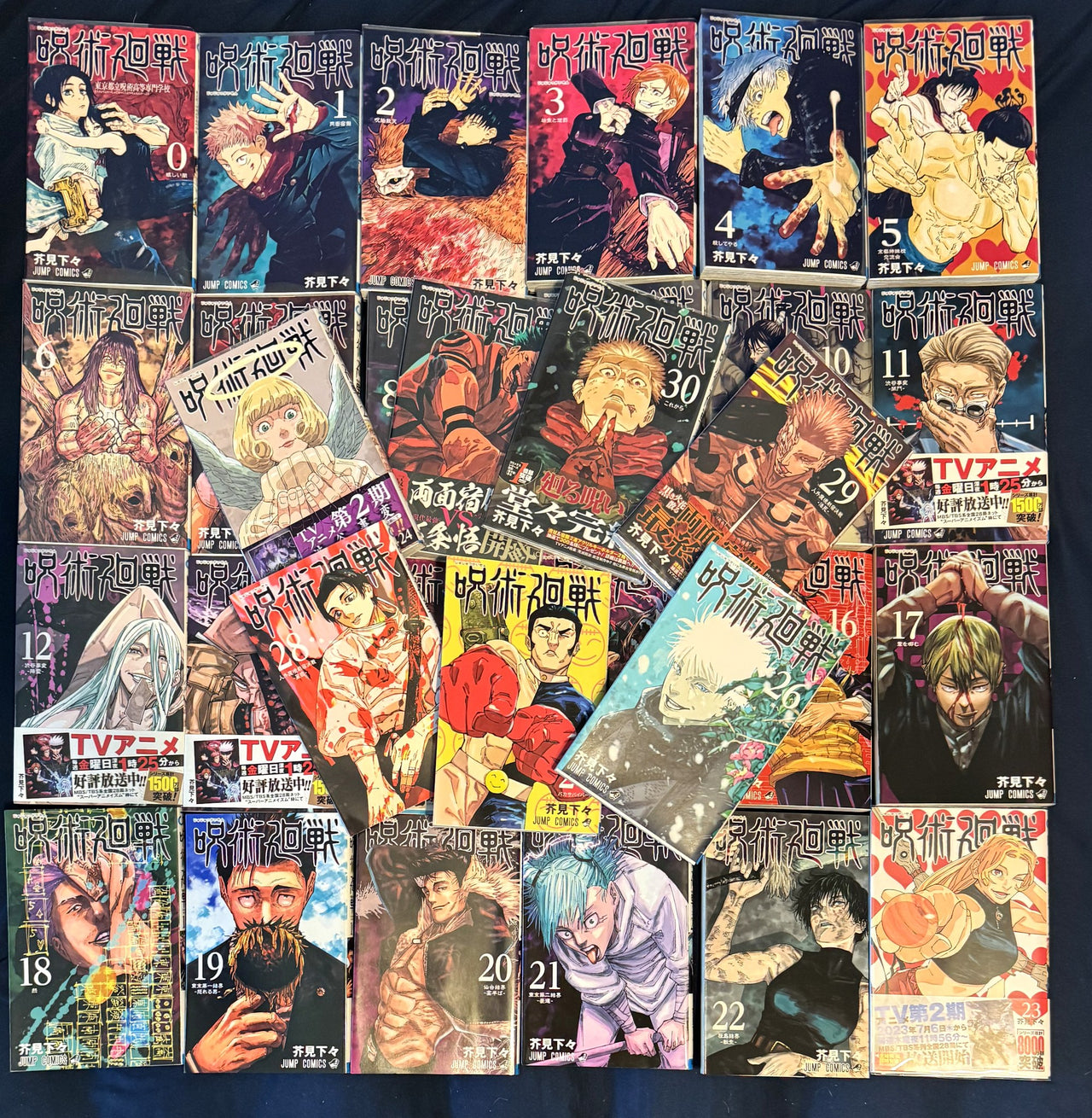 All 31 covers of the Jujutsu Kaisen Japanese manga set laid out together, volume 0 through volume 30, several still wearing their anime obi bands
