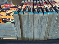 Close-up of the page edges of the used Demon Slayer volumes showing honest reading-grade tanning