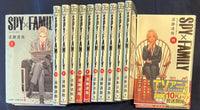 SPY x FAMILY volume 1 and volume 15 covers beside the numbered spines, volume 15 still wearing its original obi band